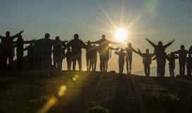 Plusieurs personnes marchent vers le soleil